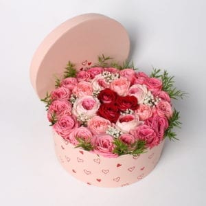 Rooscadeau - Bloemcreatie; Rozentaart in roze giftbox, gevuld met roze en rode rozen. Leuke ronde cadeaubox met hartjes