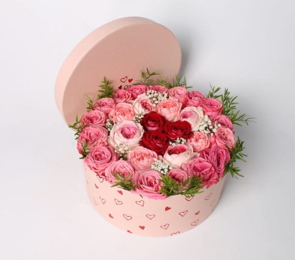 Rooscadeau - Bloemcreatie; Rozentaart in roze giftbox, gevuld met roze en rode rozen. Leuke ronde cadeaubox met hartjes